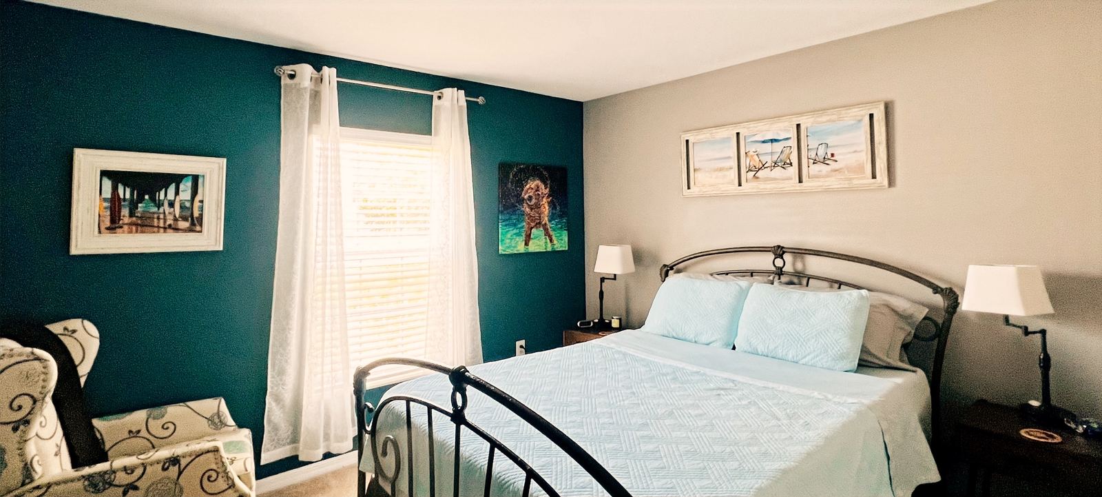 Deep teal accent wall in a coastal-styled bedroom